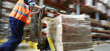 Man wheeling a cart in a warehouse